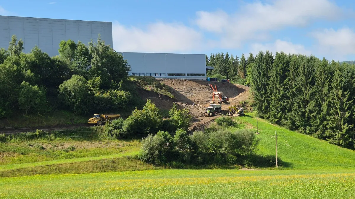 Bagger und Muldenkipper beim Bau der bewehrten Erde